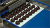 Smodellatore automatico per lo smodellaggio di praline o tavolette di cioccolato contenute all'interno degli stampi